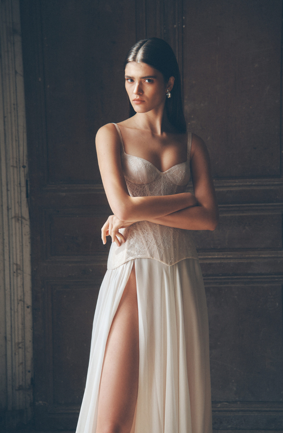 model is wearing a sleeveless spaghetti strap a-line wedding dress with a basque waist
