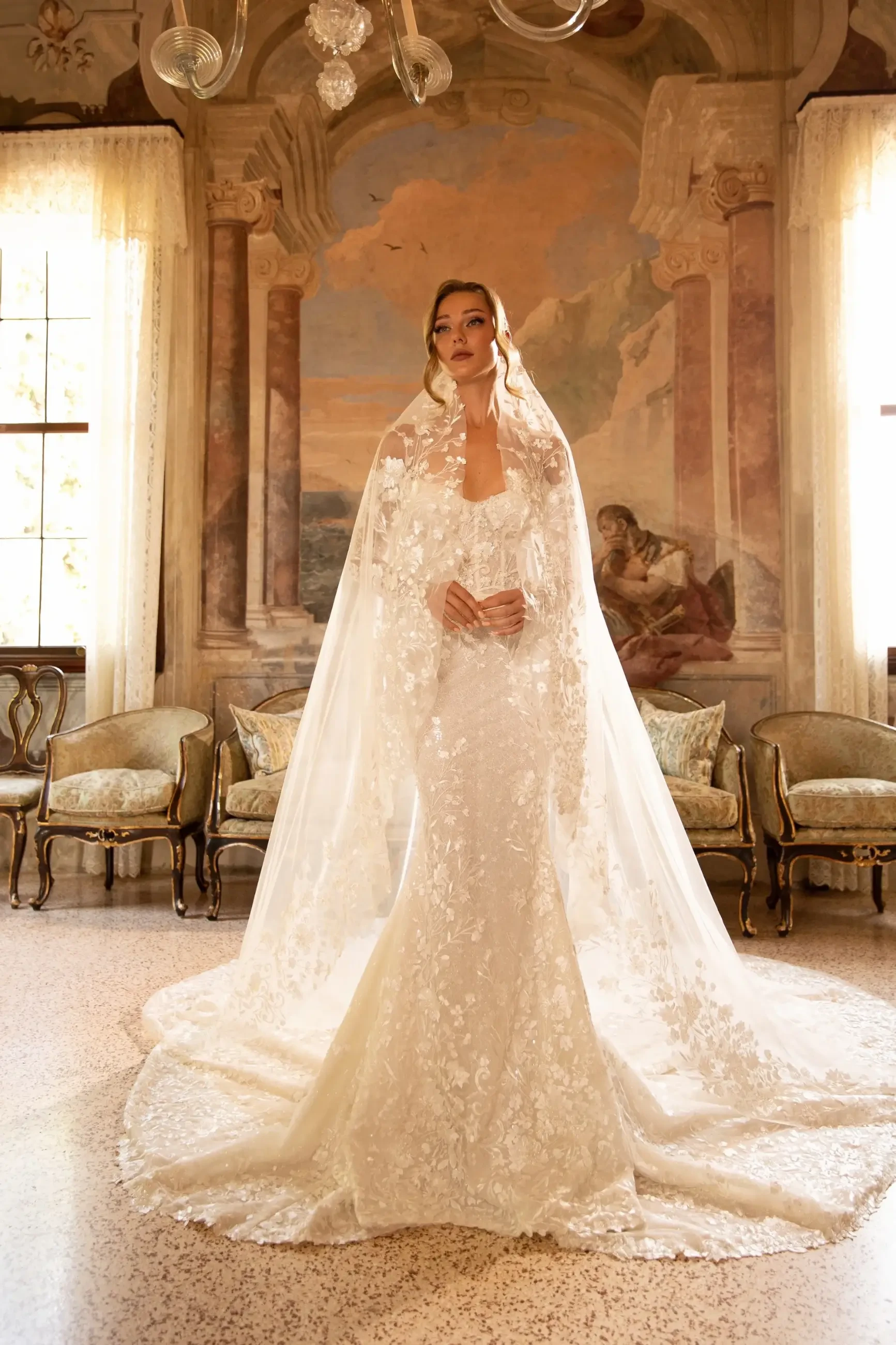 Model is wearing an off the shoulder lace fit and flare wedding dress 