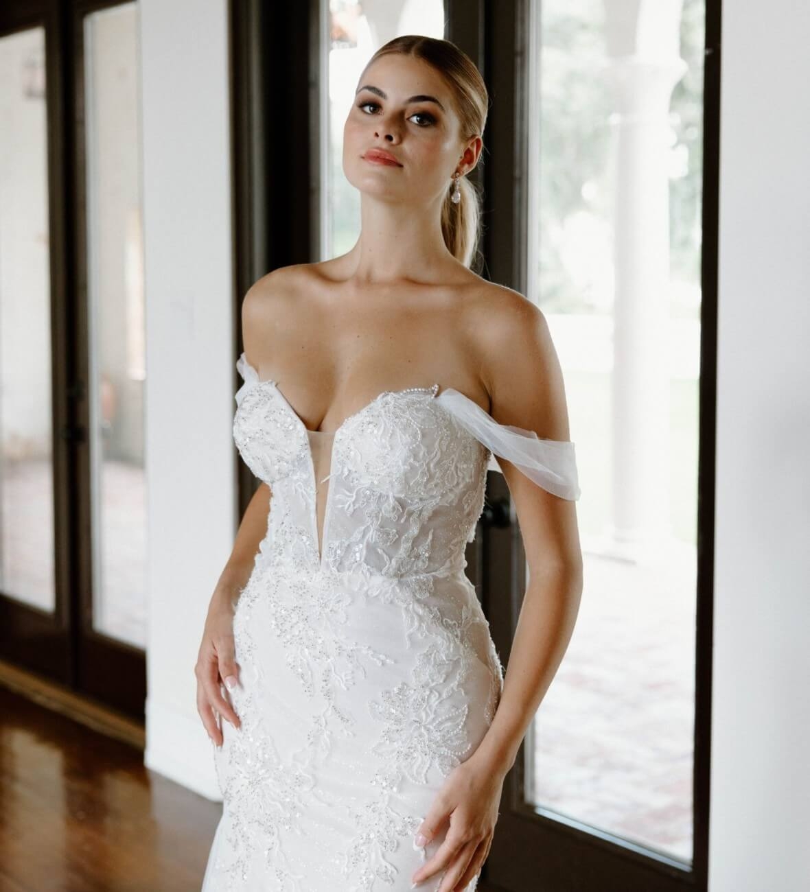 Model wearing a white dress near the window